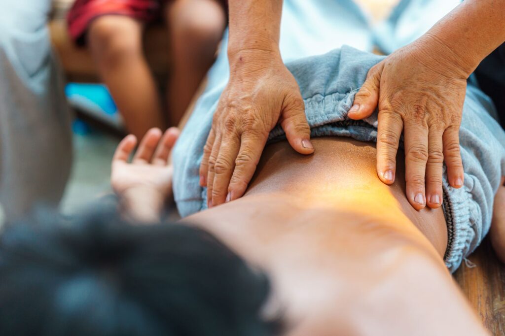 A soothing back massage performed by a therapist outdoors, focusing on relaxation and well-being.