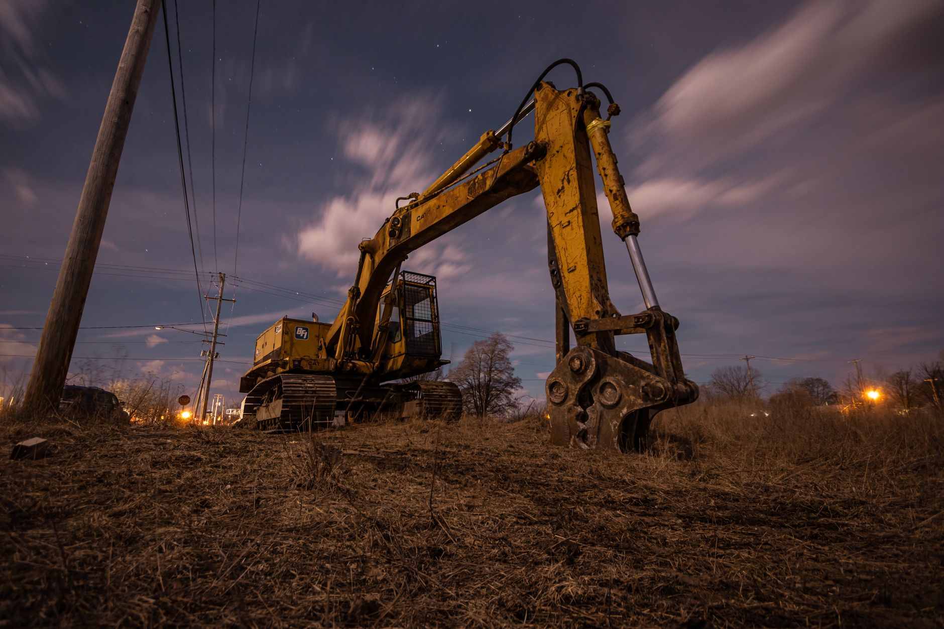 A powerful excavator sits in a field under a starry sky in Greenville, Michigan.
