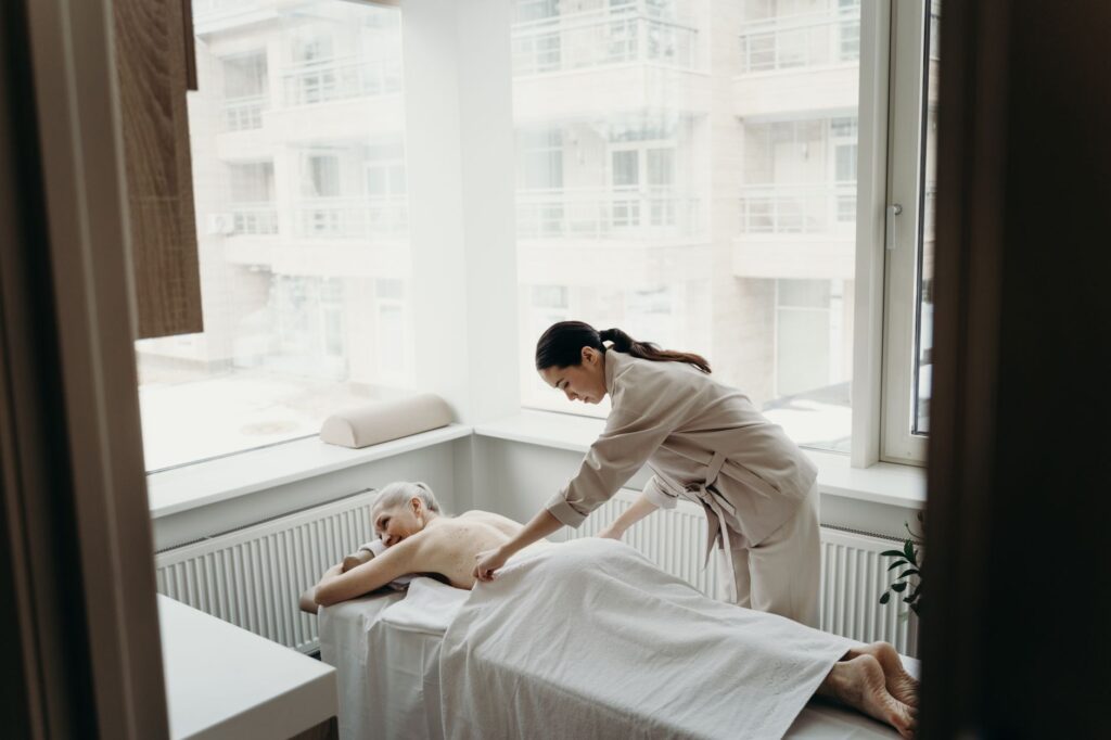 A relaxing spa day with a woman receiving a massage from a therapist indoors.
