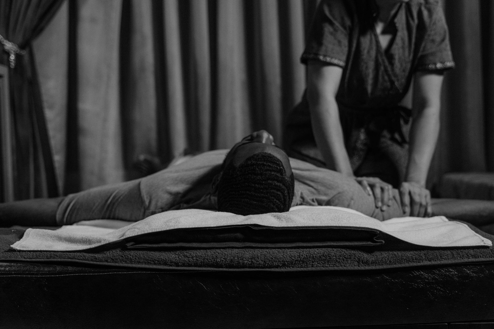 Therapeutic massage session with a masseur providing relaxation to a client in a calming environment.