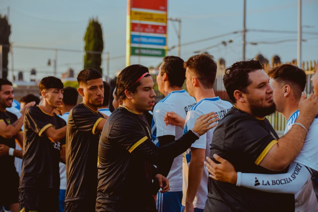 Two soccer teams in sportswear greet each other before a match, embodying sportsmanship.